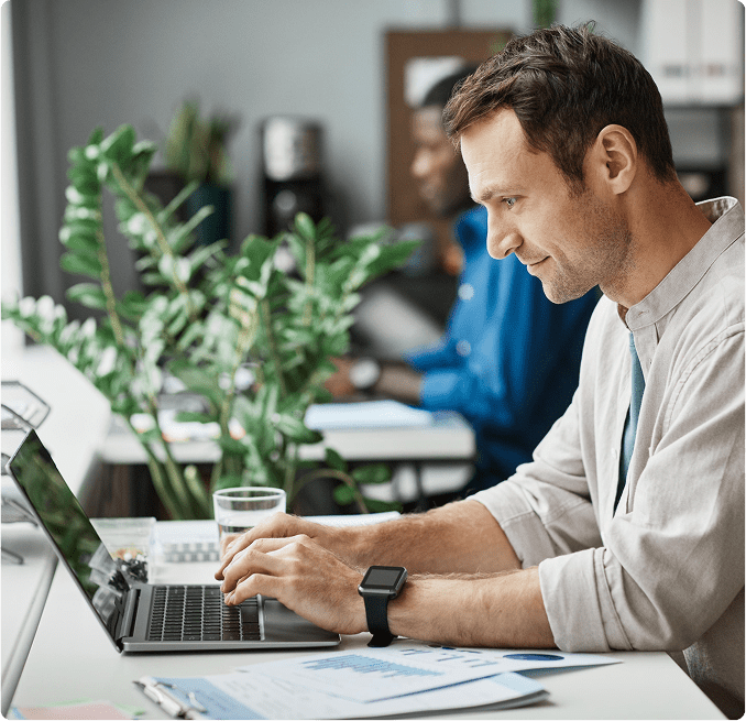 man working on cash flow documents on laptop